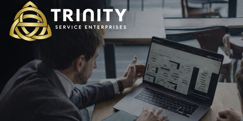Ejecutivo revisando plataforma de administración de préstamos en laptop, representando la gestión financiera en la industria de la propiedad vacacional, con logo de Trinity Service Enterprises
